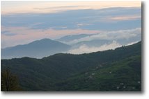 Fotografie Savignone - Panorami - La frazione Gualdrà e il Santuario della Guaria tra le nebbie al tramonto. Da Montemaggio (Chiappazza)